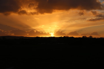Fototapeta na wymiar Orange sunset over the hill