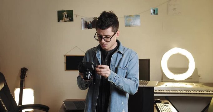 young guy, male blogger. Techno blogger shows how to adjust, customize control the camera and the manual steadicam