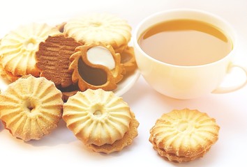Beautifully laid out cookies on a saucer. White cup with black tea. Tea ceremony.
