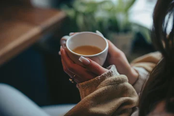Fototapete Tee Woman hands holding cup with tea in cafe  © antgor