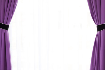 Transparent tulle with purple hue is covered on sides with purple curtains with black accents