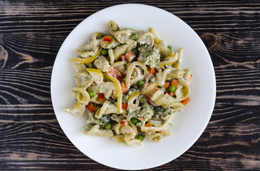 pasta with vegetables and cheese on a white plate top view homemade food