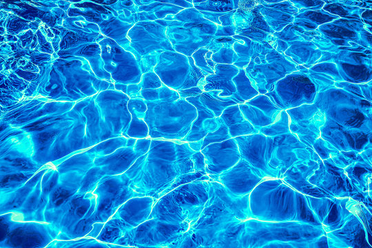 Abstract dark blue clear water in swimming pool. Neon light water effect.