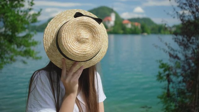 woman is changing face expression and grimacing on shore of Bled lake and island