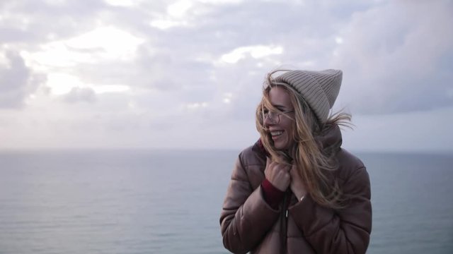 Portrait of young woman teenager traveler in glass on coast of normand.
