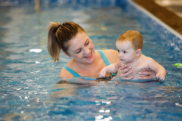 Female and child swim in water pool.