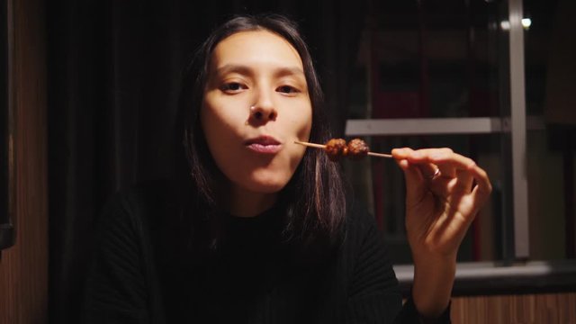 Young Mixed Race Woman Eating Delicious Soy Meat Satay In A Cafe. Vegan Food Concept. 4K Footage.