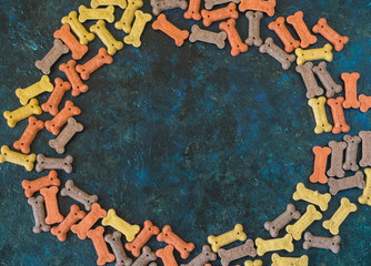 Delicious of dog snack biscuit in shape of bone of copy space on the blue background in pastel tone, Can use background , Advertising for pet food.