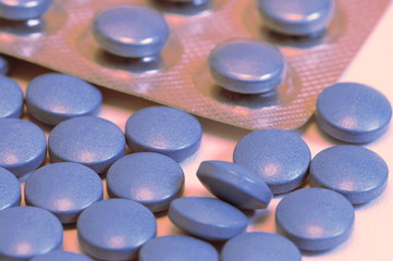 Blue medicine pills and blister pack. blue tablets of medicine, shallow depth of field. Medicine concept of viagra, medication for stomach, erection, sleeping, digestive, drugs