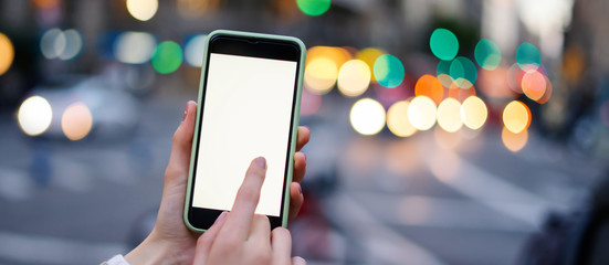Closeup photo of female hands holding modern smartphone with blank screen. Mockup ready for text...