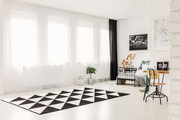 Elegant bright bedroom interior with copy space and black and white patterned rug on the floor
