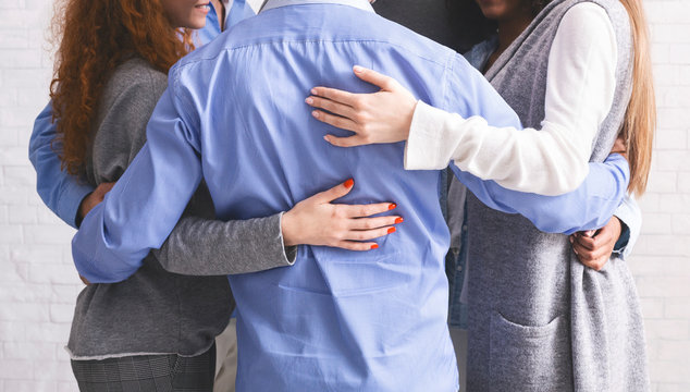Group of diverce people standing in circle and embracing each other