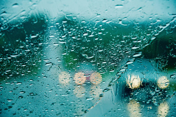 Heavy torrential rain thorugh the windscreen the windscreen. Cars with headlights are barely seen...