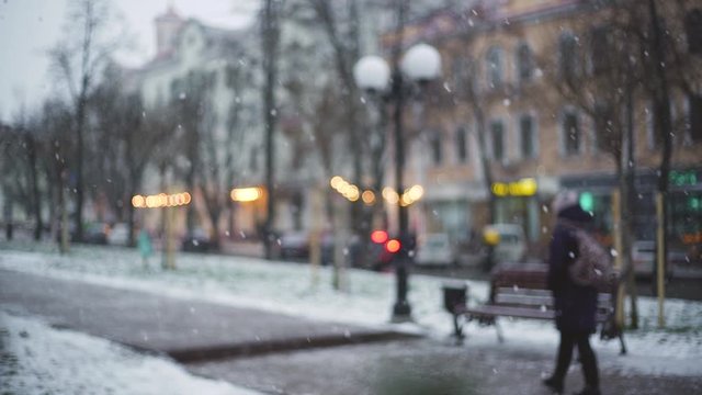Beautiful winter snowy weather in streets of small town. Shallow depth of field, focus in foreground at white fluffy snowflakes.