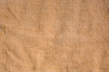 Bagging fabric background. Textile texture pattern for backdrops. Coarse bag woven canvas in brown and yellow colors for design decoration