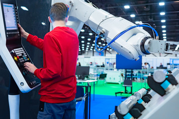 Engineer at the control panel and a robot on the background of the engineering laboratory....