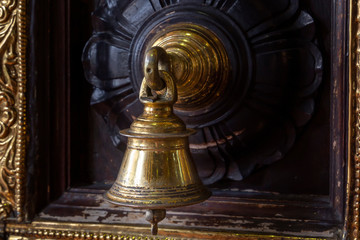 Fototapeta na wymiar Antique bronze bell on the door of a Hindu temple. Close-up