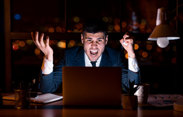 Mad Businessman At Laptop Shouting Sitting In Office At Night