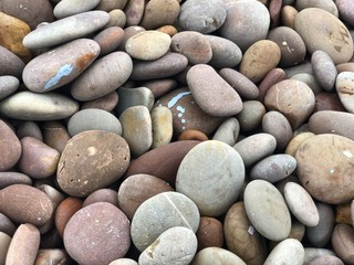 Fototapeta na wymiar Pebbles at the beach with blue colour