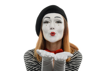 Woman sends flying kisses to you. Studio shot of a female mime artist