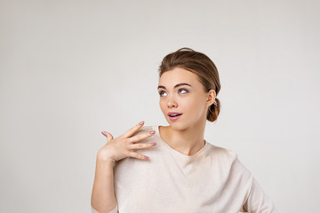 Obraz premium Portrait of young surprised beautiful woman screaming with shocked facial expression and looking to the side on gray background