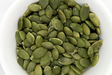 bowl with pumpkin seeds on a white background