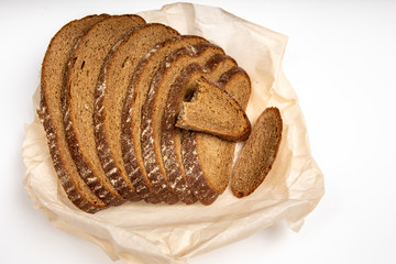 Rye bread cut in pieces lying on the baking paper on a white background