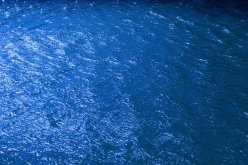 早春の風のある川面