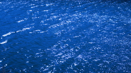 早春の風のある川面