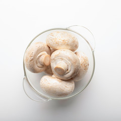 Champignon mushrooms in glass bowl isolated on white