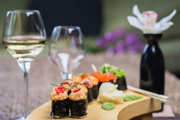 Set of several different rolls on a wooden stand on a table in a Japanese restaurant. Japanese traditional sushi and rolls.