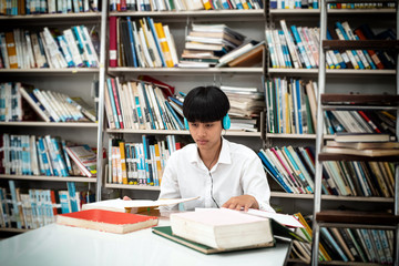 Young teenager searching data from book,at library