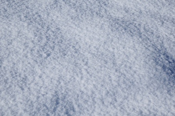 Fototapeta na wymiar A snow-white background consisting of freshly fallen pure snow. The sun shines on a snowy surface and sparkles in crystals of snow.