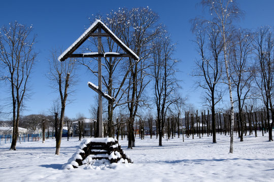 Krasnodar, Yaroslavl stanitsa January 2020 in the park. A wooden cross is installed on the hill, trees grow around and everything is covered with snow. Houses are visible in the distance. Editorial