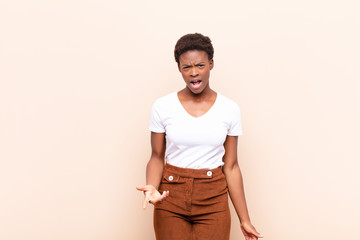 young pretty black womanlooking angry, annoyed and frustrated screaming wtf or what‚Äôs wrong...