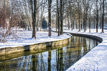 Winter city sunny park with river and trees