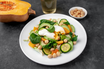 Bowl Buddha. chicken, broccoli, chickpeas, pumpkin, avocado, carrot, tomato, lettuce on a plate  on a stone background