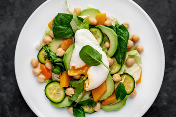Bowl Buddha. chicken, broccoli, chickpeas, pumpkin, avocado, carrot, tomato, lettuce on a plate  on a stone background