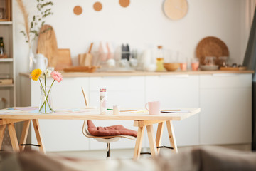 Background image of warm toned home interior with cozy wooden kitchen and flowers on table, copy space