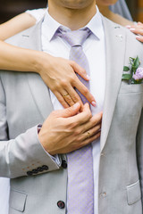 Hands of the bride and groom with wedding rings. The groom holds the bride's hand