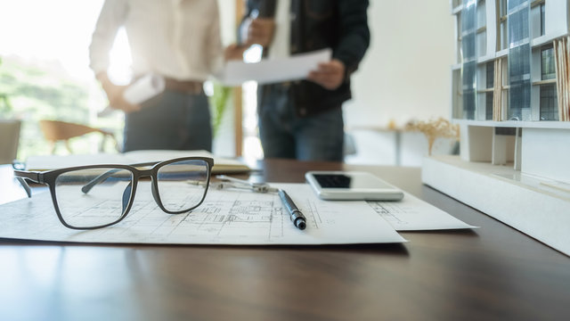 Engineer or architect teamwork working on construction project with building model and blueprint in office. Construction concept.