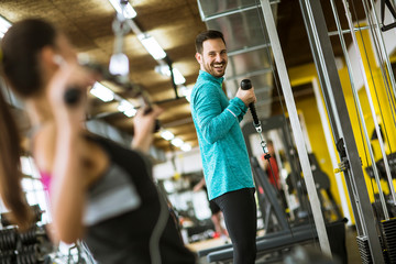 Young couple exercise bodybuilding exercises in the modern gym