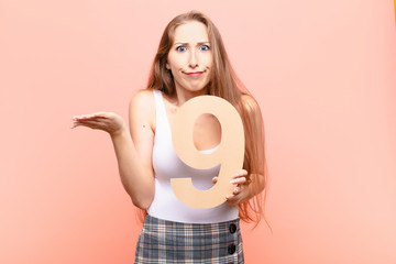 yound blonde woman angry, anger, disagreement, holding a number 9.