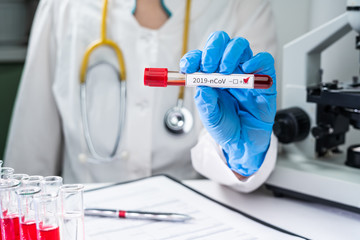 Nurse wearing respirator mask holding a positive blood test result for the new Coronavirus, originating in Wuhan, China