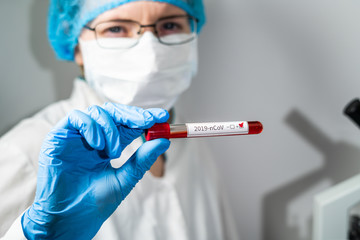 Nurse wearing respirator mask holding a positive blood test result for the new Coronavirus, originating in Wuhan, China