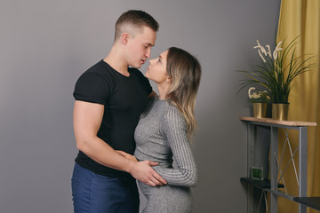 Slender nice girl snuggles up to her man indoors.