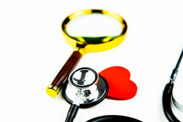 Stetoskop, serce i lupa lekarska na białym tle - obrazy, fototapety, plakaty