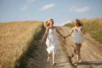 Adult mother with daughter. Beautiful girl in a white dress. Family in a summer field