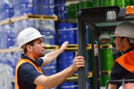 Warenlagerung und Arbeiter in einem Depot mit &Ouml;lf&auml;ssern eines Chemiewerkes // Workers in logistics company