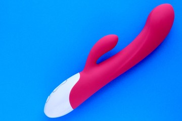 Sex toy for adult, design pink dildo vibrator isolated on blue background. Concept of sex,...
